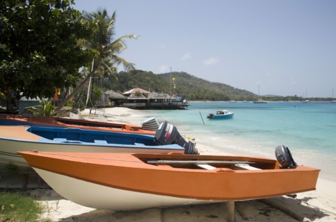 WEST INDIES, St Vincent & The Grenadines, Mustique, Fishing boats on beach in Britannia Bay with