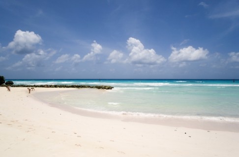 WEST INDIES, Barbados, Christ Church, Couple walking towards sea defences on Rockley Beach also