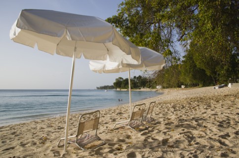 WEST INDIES, Barbados, St Peter, Sunshade umbrellas on Gibbes Bay beach in late afternoon