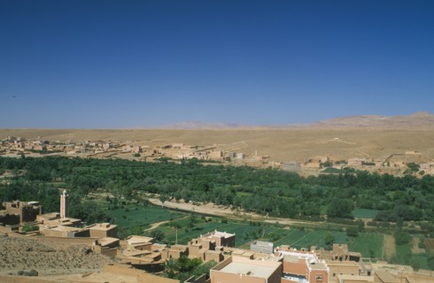 MOROCCO, Tinghir, Town buildings overlooking agricultural land and oasis.