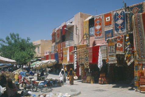 MOROCCO, Marrakesh, "The souk with carpets displayed from walls and awnings of shopfronts opposite