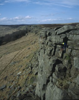 ENGLAND, Derbyshire, Stanage Edge, View northwards along edgeof gritstone craggs with rock climbers