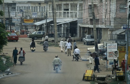 NIGERIA, Kano, Street scene in the business district with people and traffic and criss crossing