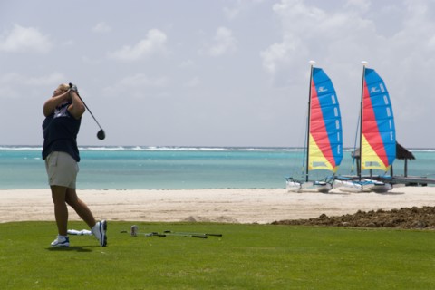 WEST INDIES, St Vincent & The Grenadines, Canouan, Lady golfer teeing off on the Raffles hotel