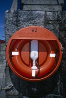 UNITED KINGDOM, Channel Islands, Guernsey, St Peter Port. Red Lifebuoy attached to sea wall.