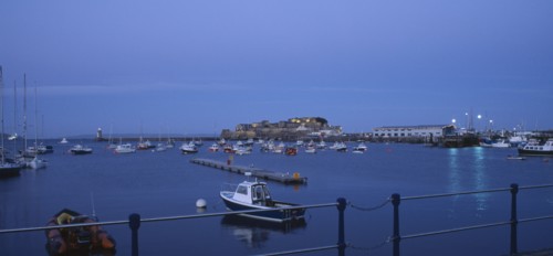 UNITED KINGDOM, Channel Islands, Guernsey, St Peter Port. Cornet Castle at dusk seen from across