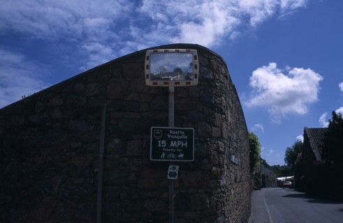 UNITED KINGDOM, Channel Islands, Guernsey, St Saviours. Convex mirror on stone wall with reflection