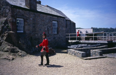 UNITED KINGDOM, Channel Islands, Guernsey, St Peter Port. Castle Cornet. Noon Day Guard walking in