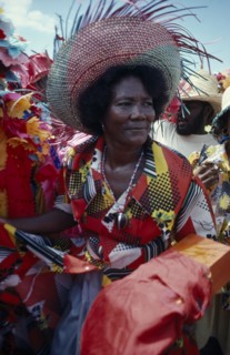 HAITI, People, Three-quarter portrait of woman at a Ra Ra procession wearing wide brimmed straw hat