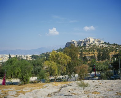 GREECE, Central, Athens, A road with trees either side in the foreground with the Acropolis up the