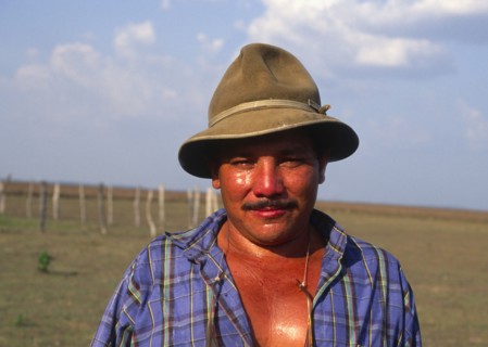 COLOMBIA, Casanare, Llanero cowboy wearing a hat and standing in a field.
