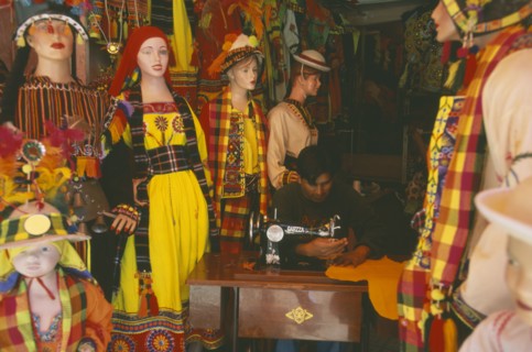 BOLIVIA, La Paz, Costume maker for Oruro Carnival. Man working on sewing machine.