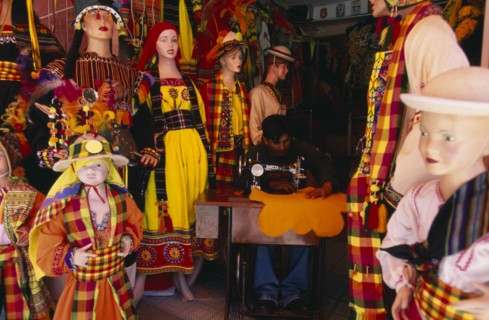 BOLIVIA, La Paz, "Costume maker for Oruro Carnival. Man working on sewing machine, surrounded by
