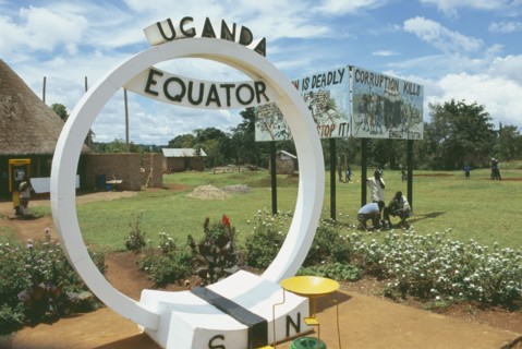 UGANDA, Equator, North and South sign. Corruption kills sign in the background.