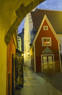 ESTONIA, Tallinn, Old Town street at night. lit by lanterns in wall brackets.