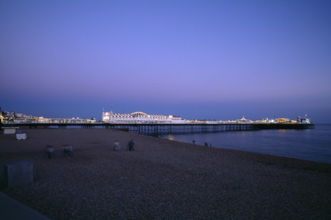 ENGLAND, East Sussex, Brighton, Brighton Pier illuminated in evening light.