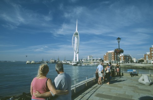 ENGLAND, Hampshire, Portsmouth, Spice Island. A couple arm in arm looking towards the Spinnaker
