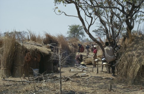 BURUNDI, Architecture, Hutu village dwellings with women cooking over open fire.