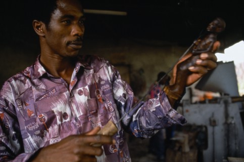 RWANDA, Gisenyi, Wood carver at Kiaka Artisans Co-operative producing goods for export and local