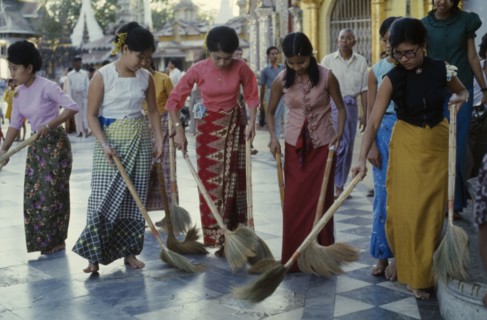MYANMAR, Yangon, Schwedagon Pagoda.  Women sweeping black and white chequered floor of pagoda.