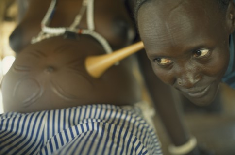 SUDAN, Bahr el Ghazal, Traditional midwife Josephine listening to foetal heart during examination