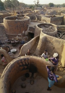 BURKINA  FASO, Tiebele, View above traditional Gourounsi village with people amongst buildings.