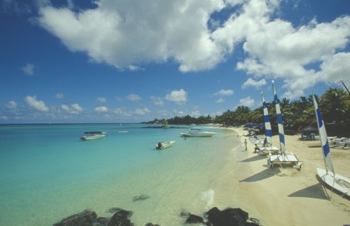 MAURITIUS, Grand Bay, The beach at the Mauritius Hotel. People next to yachts with blue and white