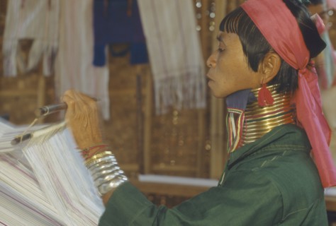 THAILAND, Chiang Rai, "Woman weaving at Karennie village. Paduang, long neck, metal rings."