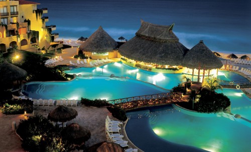 MEXICO, Jalisco ,  Puerto Vallarta, "A swimming pool surrounded by sun loungers, wooden thatched