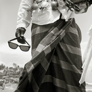 INDIA, Kerala, Kovalam Beach, A sunglass-seller displays his wares on a tourist beach in southern