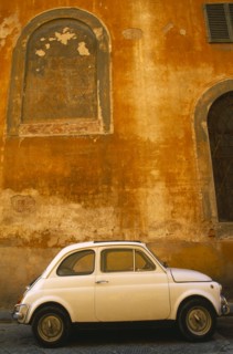 ITALY, Tuscany, Florence, White Fiat 50 parked outside old building with faded ochre coloured
