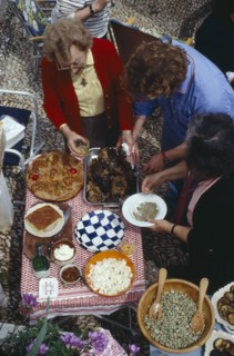 GREECE, Saronic Islands, Spetses, Women serving traditional meal for Feast of the Spitted Lamb held