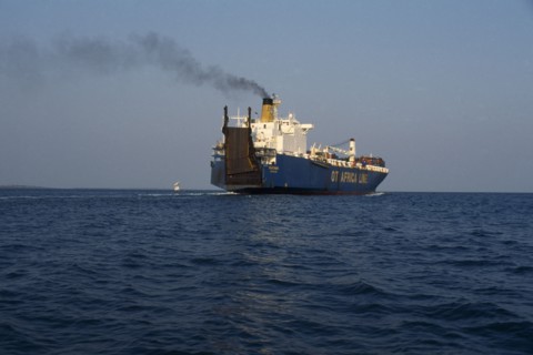 GHANA, Transport, Container ship leaving Tema port emitting stream of thick black smoke from