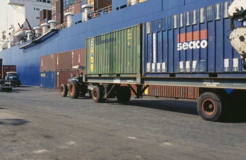 IVORY COAST, Abidjan, Container vessel docked at Abidjan port with tractor pulling trailer loaded