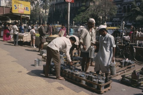 INDIA, Maharashtra, Bombay, Lunch time tiffin wallahs distributing tiffin boxes to city workers.