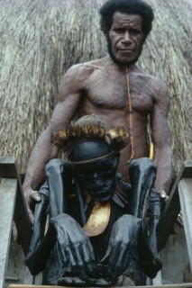 INDONESIA, Irian Jaya, Baliem Valley, "Jiwika Village. Dani Warrior man holding smoked ancestral