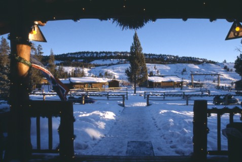 USA, Wyoming, Dubois, View of Guest cabins at the Triangle C Dude Ranch in the snow from building