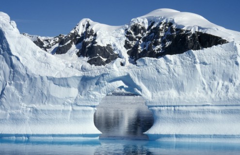 ANTARCTICA, Peninsula Region, Ice Cliffs with an arch shaped gap in the middle and snow covered