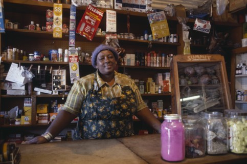 SOUTH AFRICA, Gauteng, Soweto, Portrait of shopkeeper behind counter with goods arranged on shelves