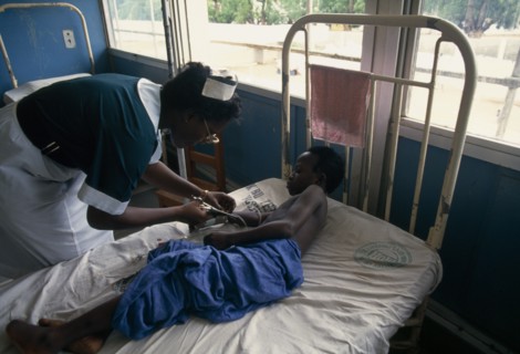 GHANA, Accra, Bedridden child being attended by nurse in children’s ward of Korle-Bu teaching