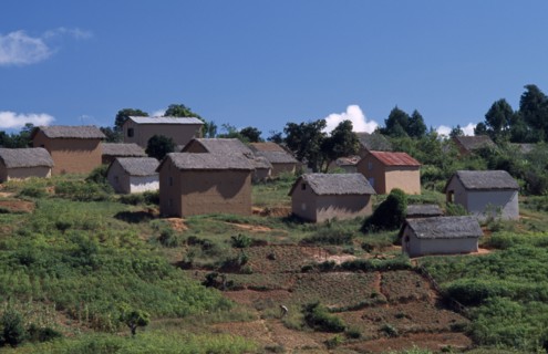 MADAGASCAR, Architecture, Road to Ambalavao. Thatched huts set into hillside