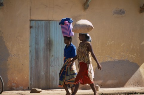 MADAGASCAR, Ambalavao, Two women wearing colourful clothing walking along a street next to a