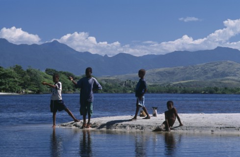 MADAGASCAR, Fort Dauphin, Lokaro, Group of children with a small dog fishing in the bay and