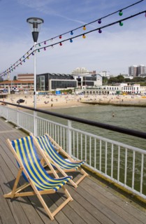 ENGLAND, Dorset, Bournemouth, Deckchairs on the Pier withThe East Beach and the Imax Complex on the