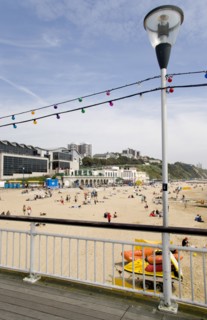 ENGLAND, Dorset, Bournemouth, The East Beach from the pier with seafront restaurants and bars.