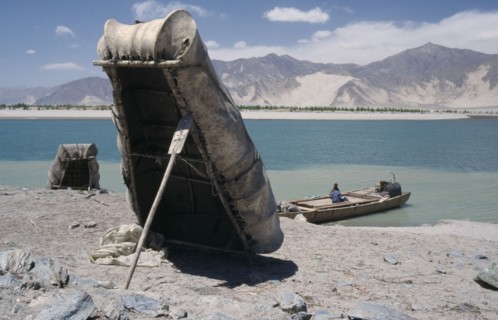 CHINA, Tibet, "Near Tsetang. Yak skin boats, one propped up by a paddle, and a local ferry beside