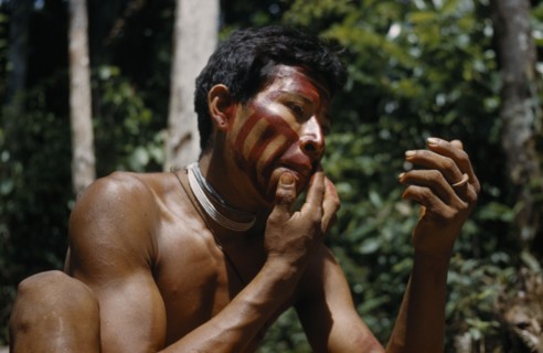 COLOMBIA, Vaupes Region, Tukano Tribe, Man applies “karajuru” / facial paint before he goes hunting