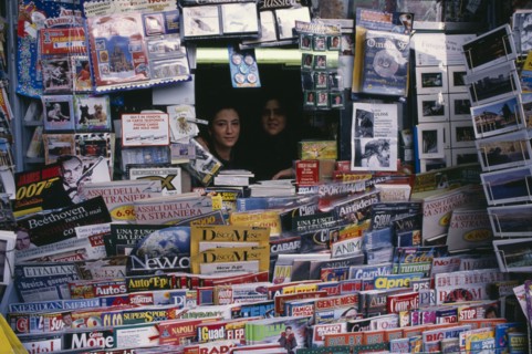 ITALY, Campania, Naples, Two women looking out from newsagents stall completely surrounded by