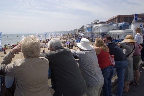 ENGLAND, Dorset, Bournemouth, Tourists watching speedboat races off the West Beach with the