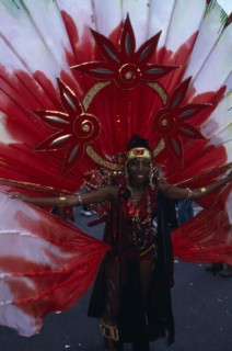 ENGLAND, London, Notting Hill carnival woman in extravagant red costume.